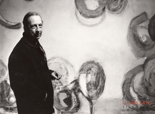 Constant in front of a mural Painting