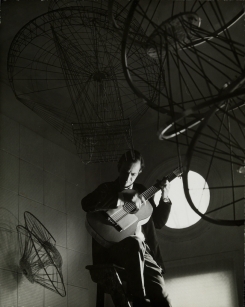 Constant Nieuwenhuys-Constant speelt gitaar op ladder, 1962